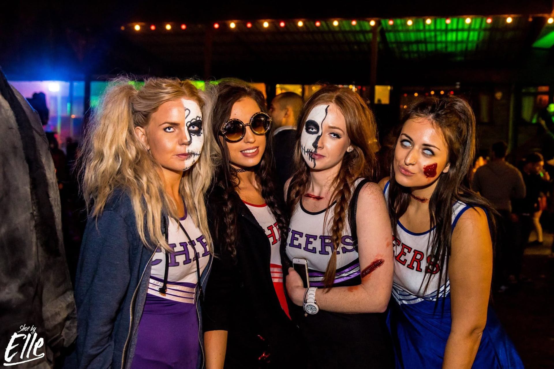 Four guests dressed as zombie cheerleaders with half-skull face paint at Zombie Fest